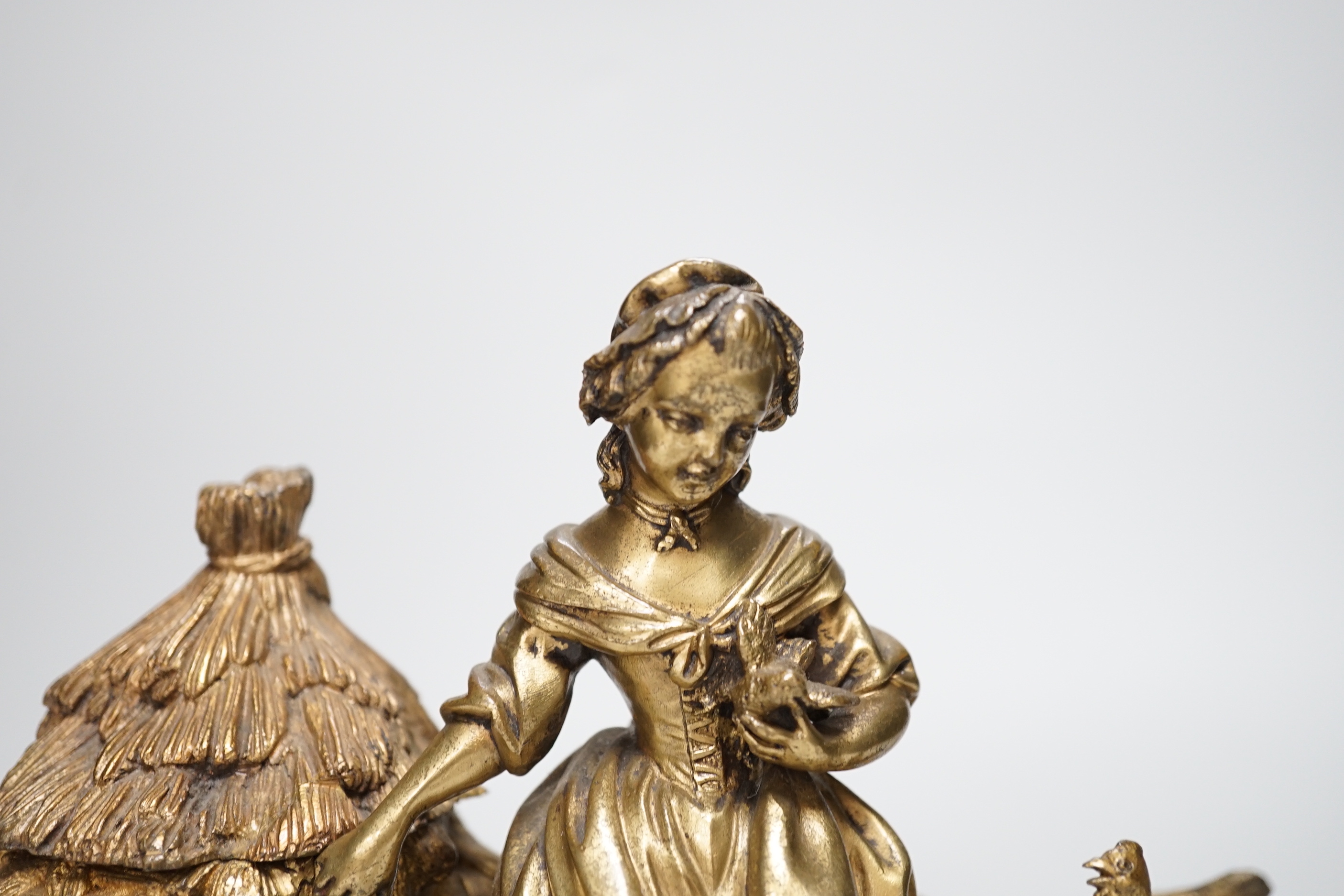 A 19th century gilt bronze inkwell decorated with a farmyard scene and country maiden, 18cm high